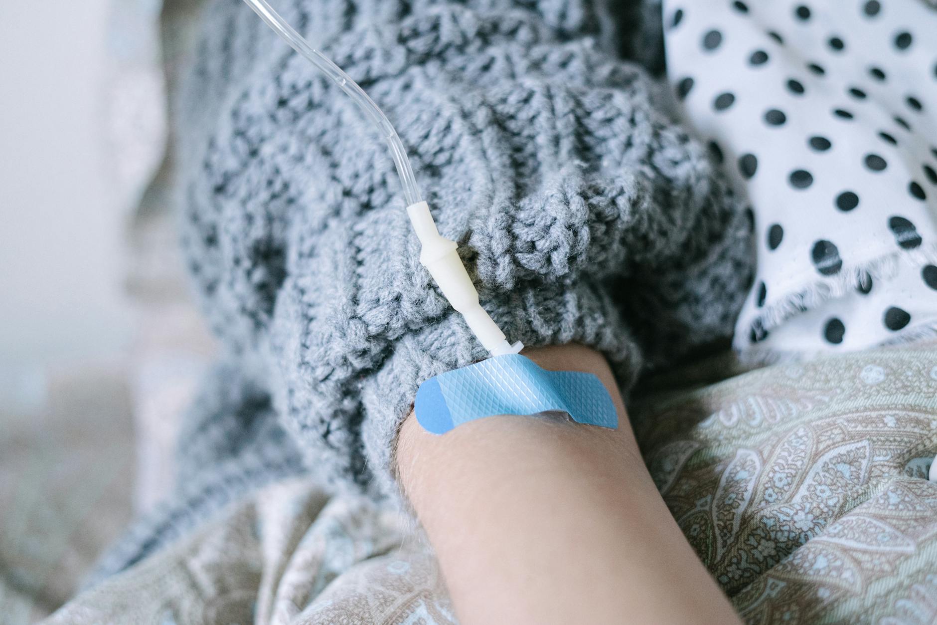 A patient relaxing under a knit blanket during an IV infusion