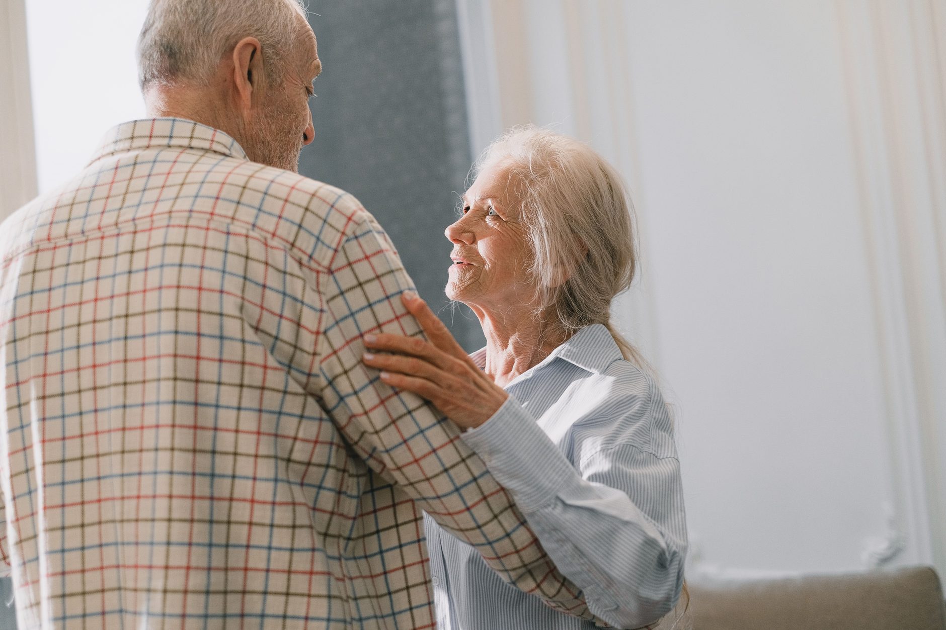 An older couple dancing together at home