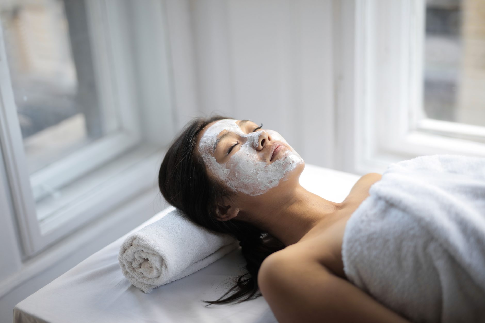 A woman resting during a facial treatment in natural light