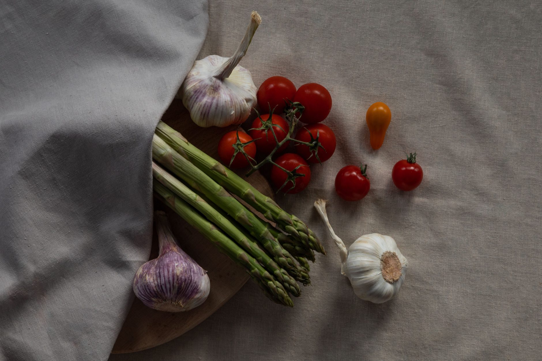 Fresh vegetables and herbs arranged on linen