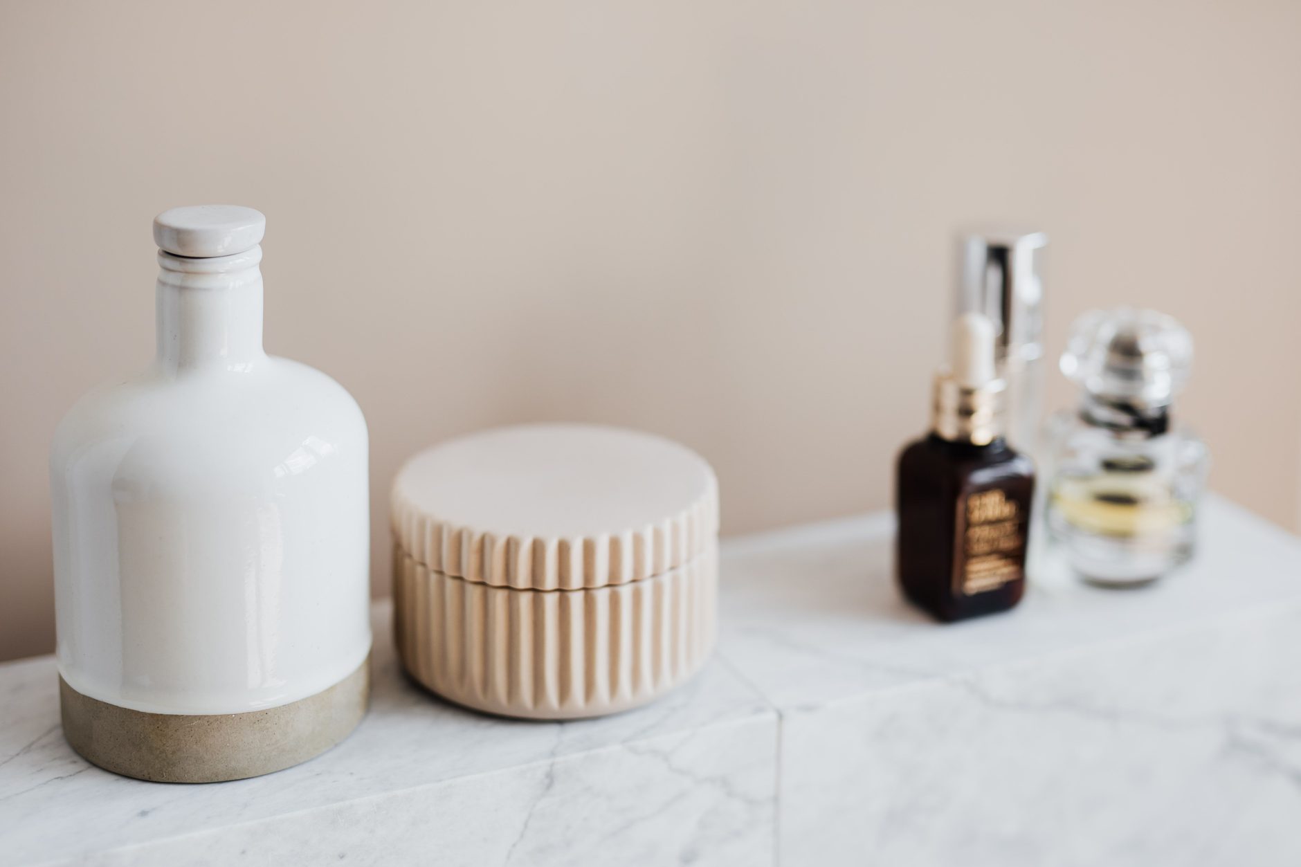 Serum and cream bottles on a marble counter