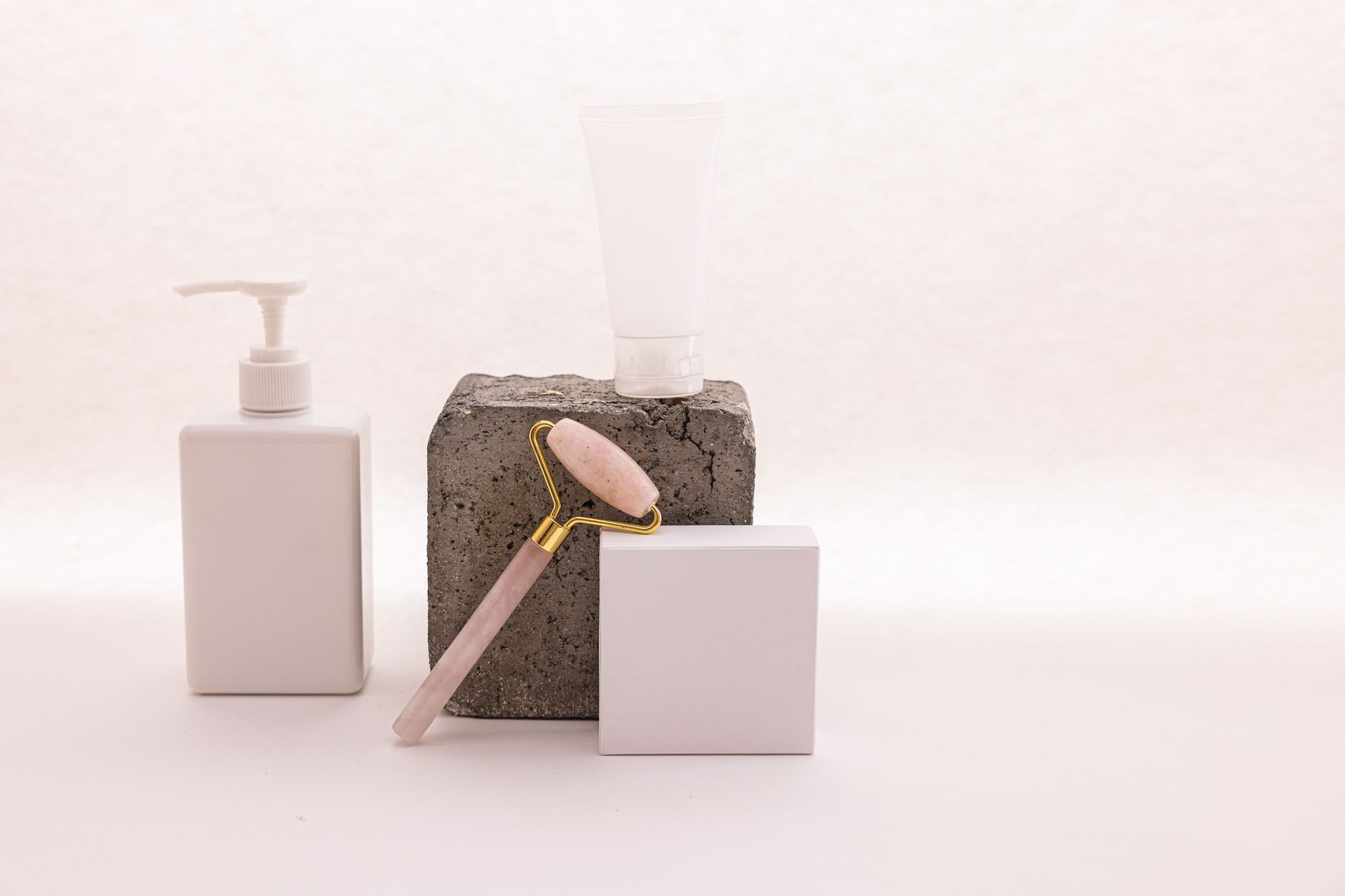Skincare bottles beside a facial roller