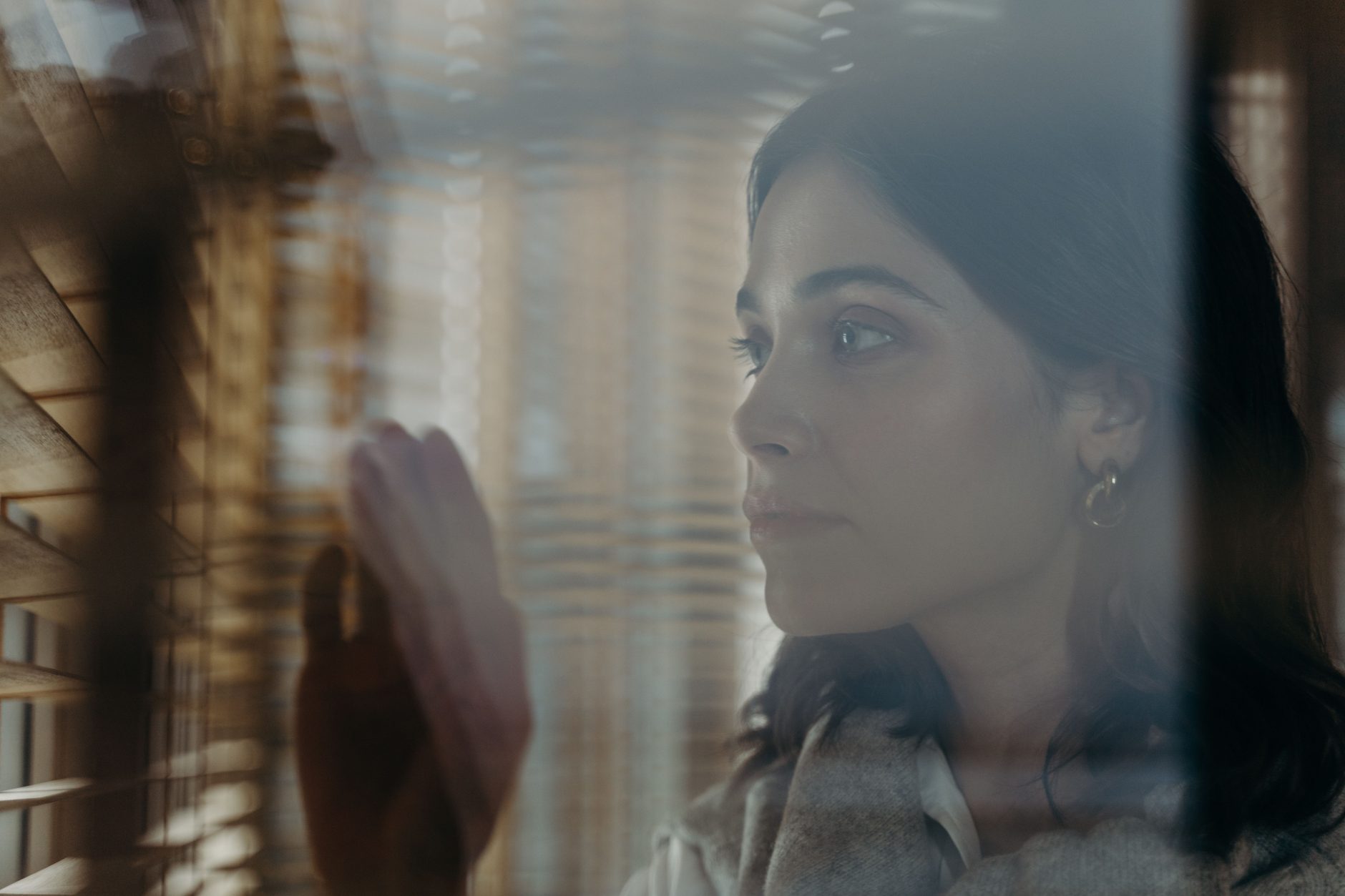 A woman looking thoughtfully through a window